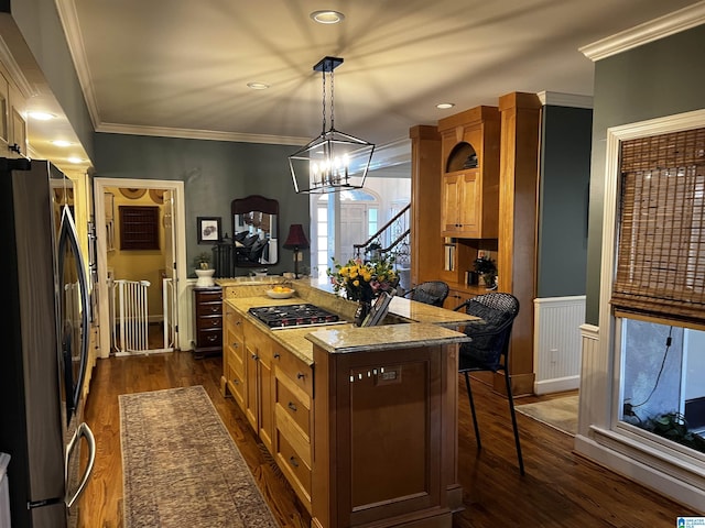 kitchen with light stone counters, stainless steel appliances, dark wood-type flooring, a kitchen island, and decorative light fixtures