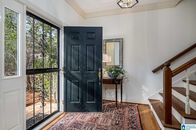 entryway with stairway, baseboards, ornamental molding, and wood finished floors