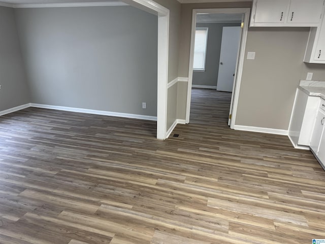 interior space with ornamental molding, dark wood-style flooring, and baseboards