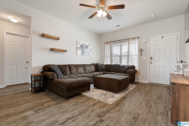 living room featuring ceiling fan and dark hardwood / wood-style floors