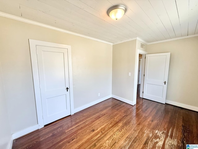 spare room with crown molding, baseboards, and wood finished floors