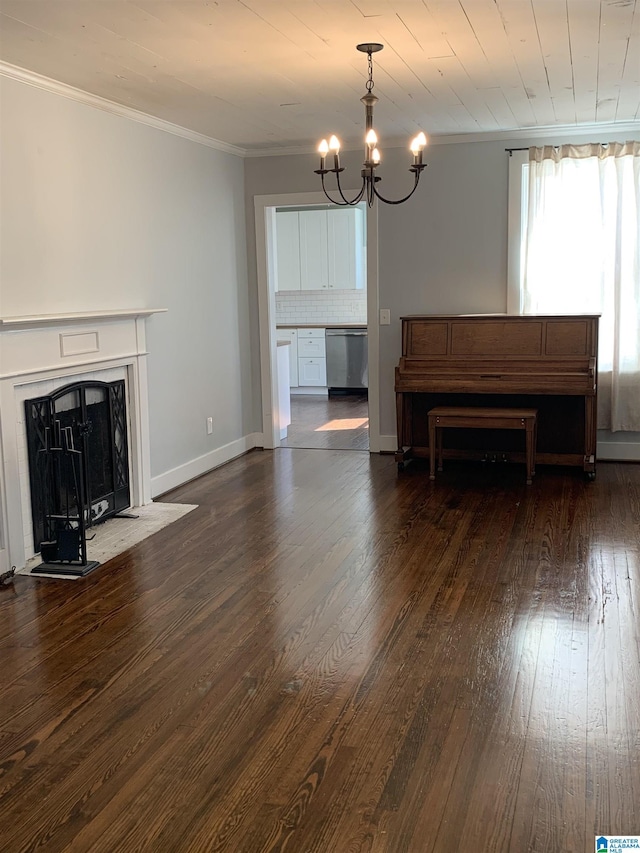 unfurnished living room with a notable chandelier, dark wood-style flooring, a fireplace, baseboards, and ornamental molding