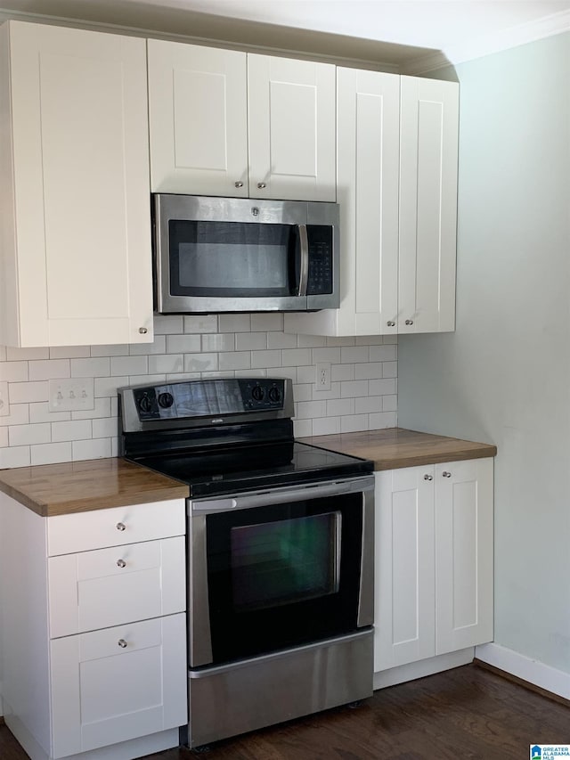 kitchen featuring stainless steel appliances, butcher block counters, dark wood-type flooring, white cabinets, and decorative backsplash