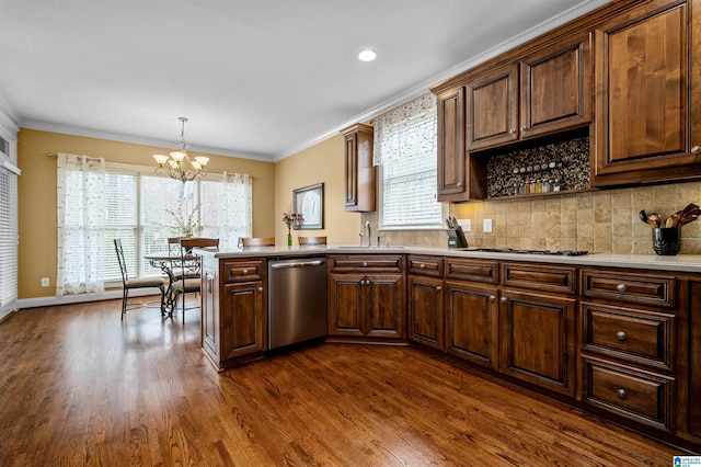 kitchen with dishwasher, decorative light fixtures, a peninsula, light countertops, and crown molding