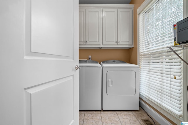 laundry room with visible vents, independent washer and dryer, and cabinet space