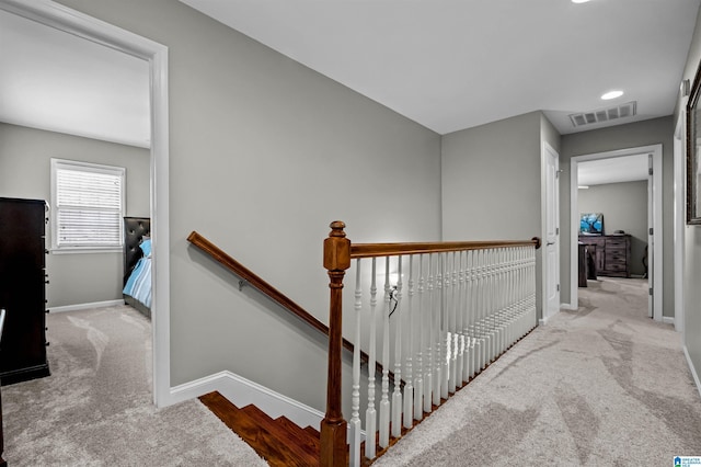 stairway with carpet floors, visible vents, and baseboards