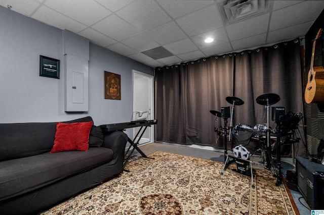 interior space with visible vents, a drop ceiling, and electric panel