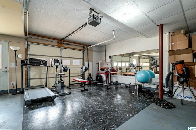 workout area with a garage and a paneled ceiling