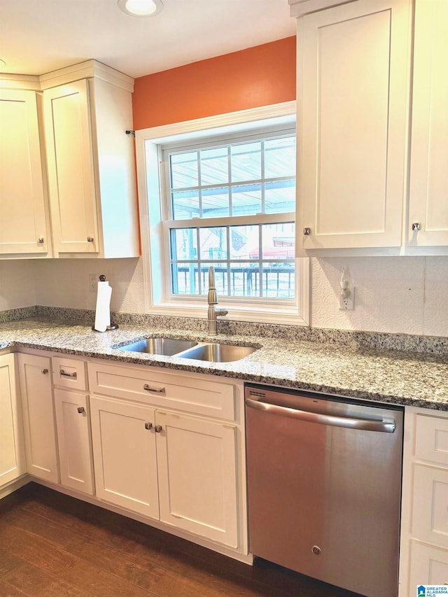 kitchen with sink, white cabinets, dark hardwood / wood-style flooring, stainless steel dishwasher, and light stone counters