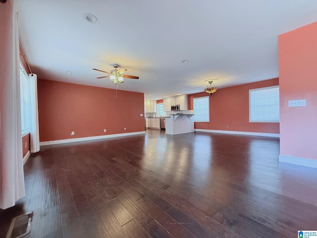 unfurnished living room with ceiling fan and dark hardwood / wood-style flooring