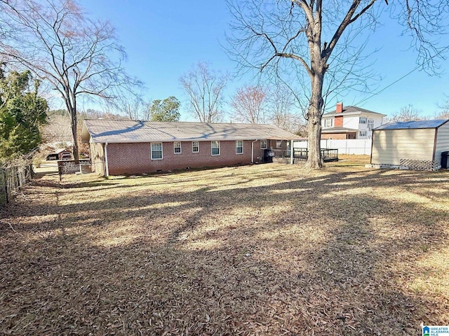 back of property featuring a yard and a shed