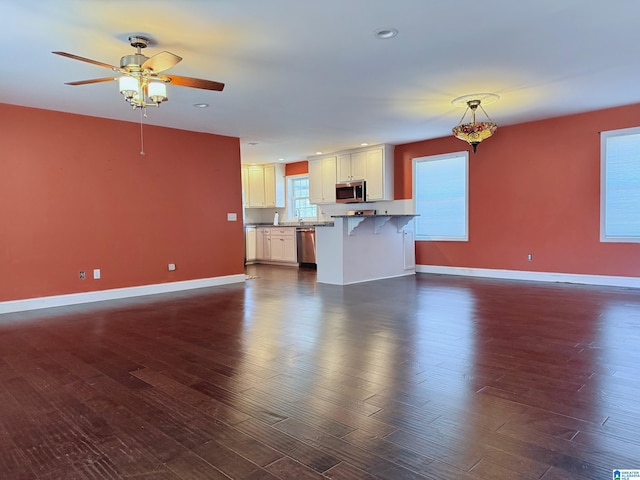 unfurnished living room featuring dark hardwood / wood-style floors and ceiling fan