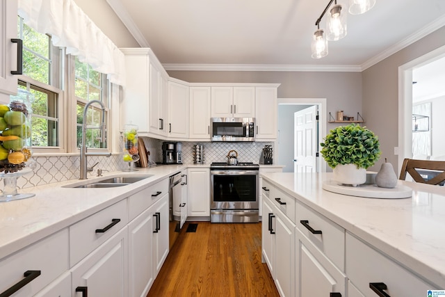 kitchen with white cabinetry, appliances with stainless steel finishes, sink, and light stone counters