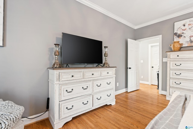 bedroom with crown molding and light hardwood / wood-style floors