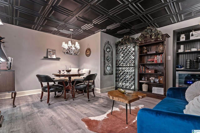 dining space featuring an inviting chandelier, beverage cooler, and hardwood / wood-style floors