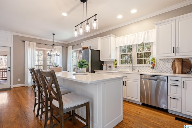 kitchen featuring stainless steel appliances, a center island, and white cabinets