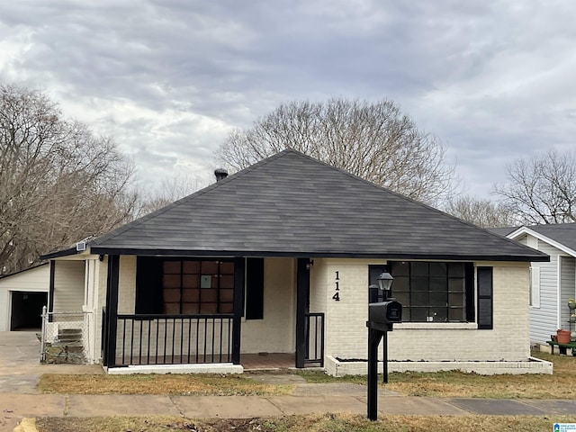 view of front of house featuring a garage and an outbuilding