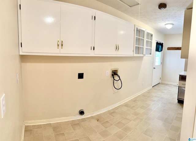 washroom with hookup for a washing machine, cabinets, and a textured ceiling