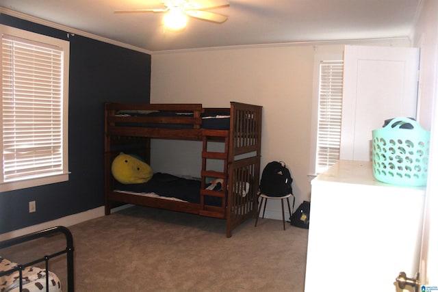 carpeted bedroom featuring ornamental molding and ceiling fan