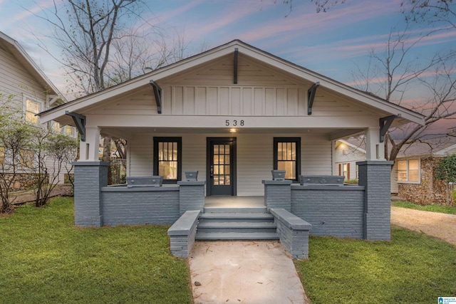 view of front of home with a front lawn, a porch, and board and batten siding