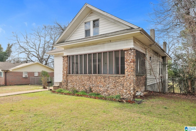 view of front facade with a sunroom and a front yard