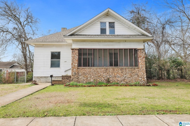 view of front of home featuring a sunroom and a front yard