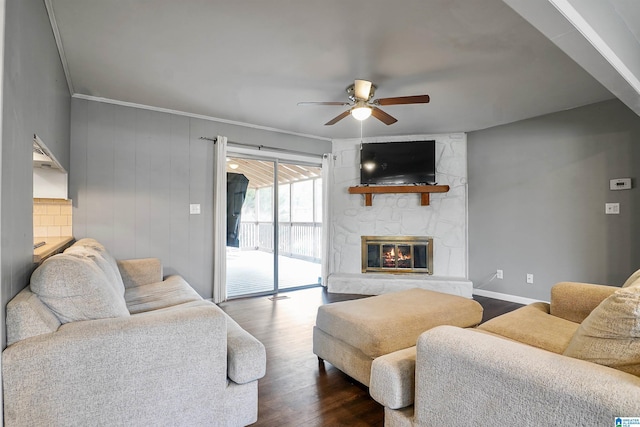 living room featuring a fireplace, ceiling fan, ornamental molding, and dark hardwood / wood-style flooring