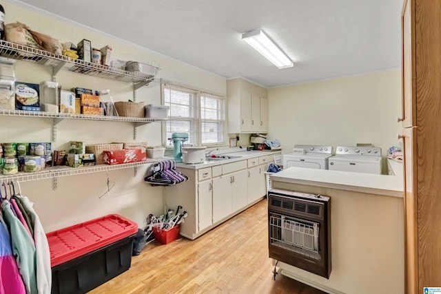 clothes washing area with cabinets, light hardwood / wood-style floors, and washer and dryer