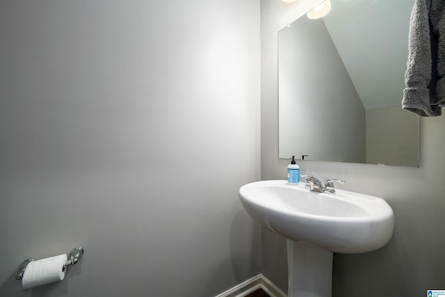 bathroom with lofted ceiling and sink