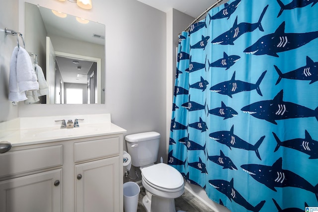 bathroom featuring vanity, curtained shower, and toilet