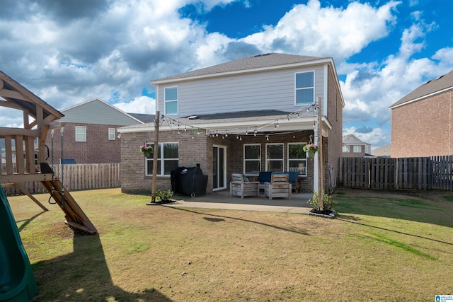 rear view of property featuring a yard, outdoor lounge area, a patio, and a playground