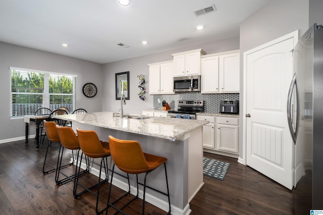 kitchen featuring white cabinetry, appliances with stainless steel finishes, sink, and a center island with sink