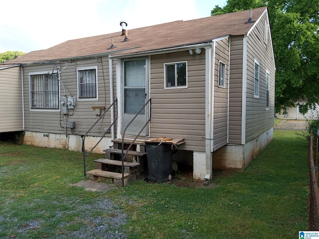 rear view of house featuring a yard