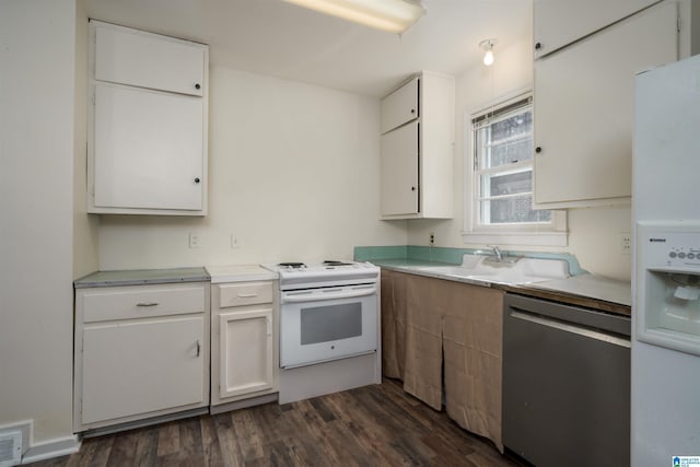 kitchen with sink, white appliances, white cabinetry, and dark wood-type flooring