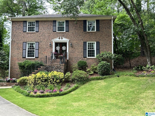 colonial home featuring a front lawn