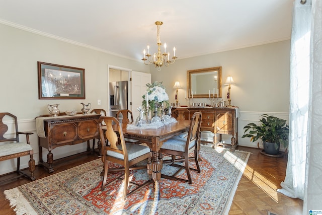 dining area with parquet flooring, ornamental molding, and a notable chandelier