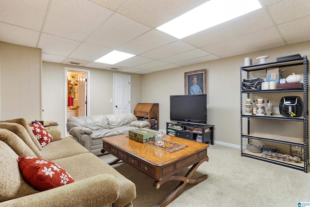 carpeted living room featuring a paneled ceiling