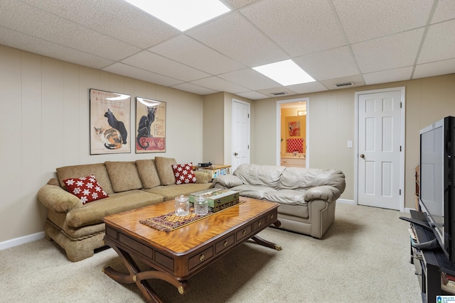 carpeted living room with a drop ceiling