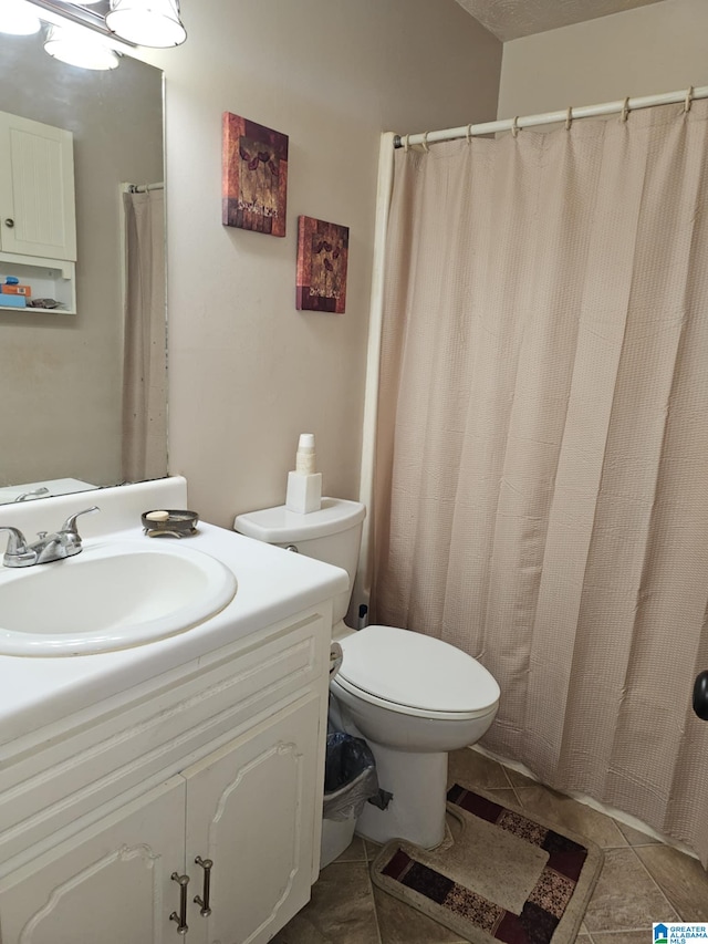 bathroom featuring tile patterned flooring, vanity, and toilet