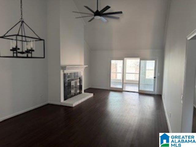 unfurnished living room featuring a high ceiling and dark wood-type flooring