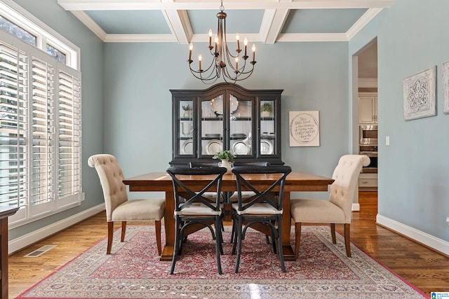 dining space with crown molding, wood-type flooring, coffered ceiling, and beam ceiling