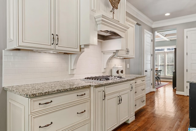 kitchen with crown molding, stainless steel gas stovetop, dark hardwood / wood-style floors, and light stone countertops