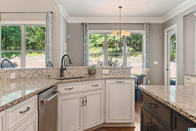 kitchen with ornamental molding, decorative light fixtures, light stone countertops, and sink