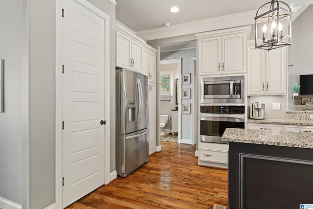 kitchen with stainless steel appliances, white cabinetry, pendant lighting, and dark hardwood / wood-style flooring