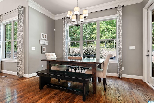 dining area with an inviting chandelier, crown molding, and dark hardwood / wood-style floors