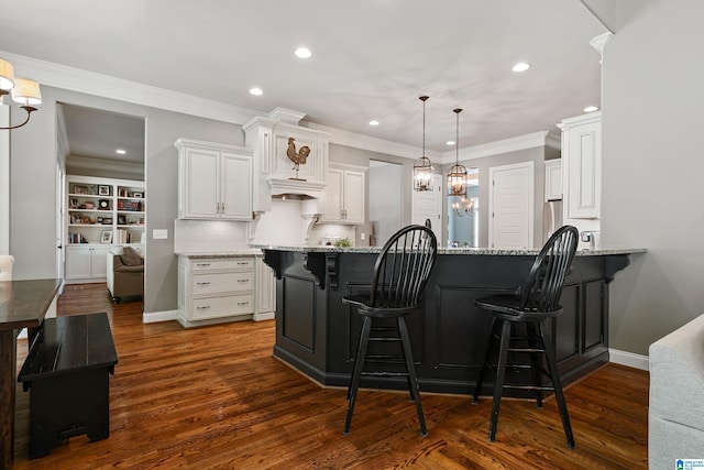 kitchen with white cabinets, a kitchen breakfast bar, kitchen peninsula, light stone countertops, and dark wood-type flooring