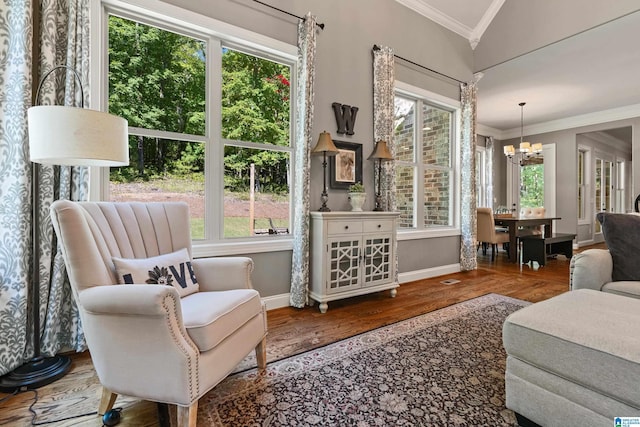 sitting room featuring hardwood / wood-style flooring, crown molding, vaulted ceiling, and a notable chandelier