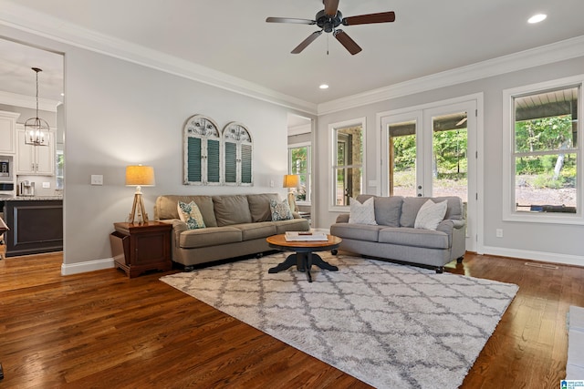 living room featuring crown molding, ceiling fan with notable chandelier, and dark hardwood / wood-style floors