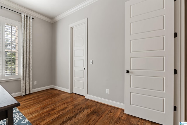 unfurnished bedroom featuring crown molding and dark wood-type flooring