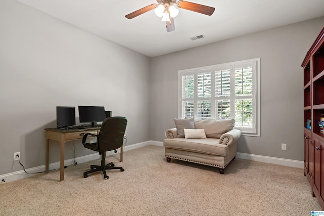 carpeted home office featuring ceiling fan